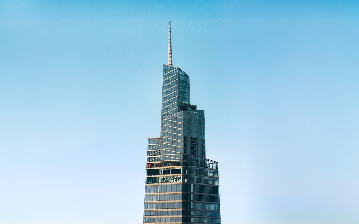 Summit One Vanderbilt skyscraper against a clear blue sky in New York City.