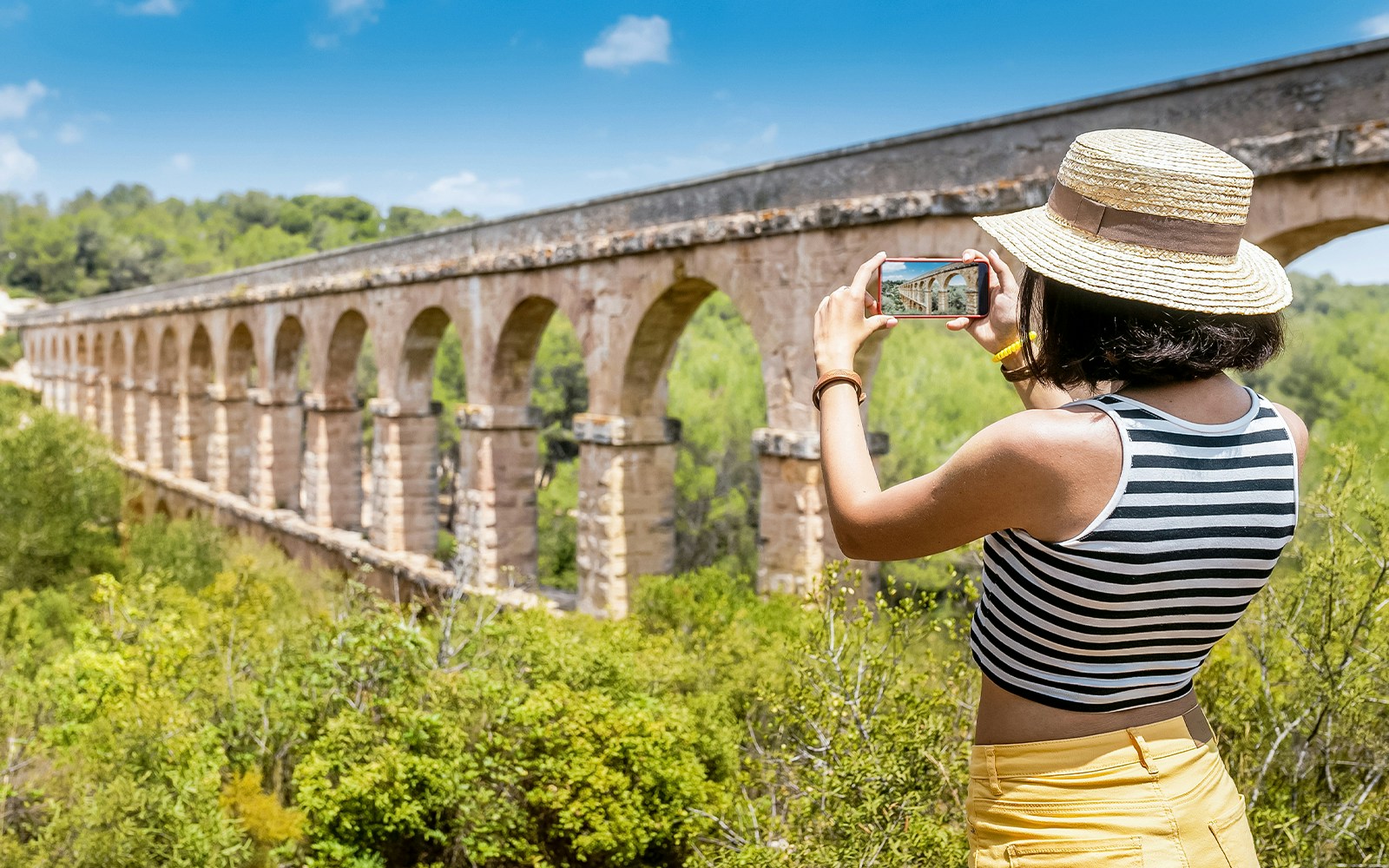 woman taking picture at Pont del Diable (Devil's Bridge)