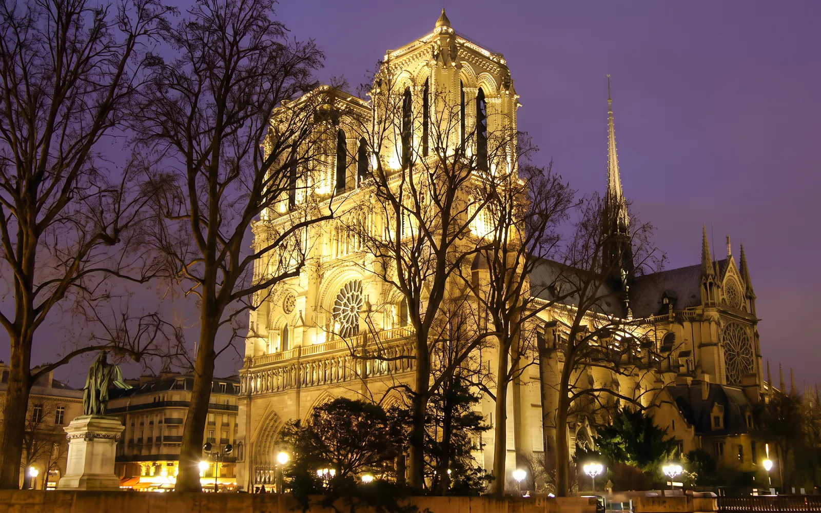 Notre Dame Cathedral illuminated at night in Paris, related to Mona Lisa Murder Mystery tour.