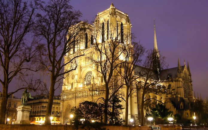 Notre Dame Cathedral illuminated at night in Paris, related to Mona Lisa Murder Mystery tour.
