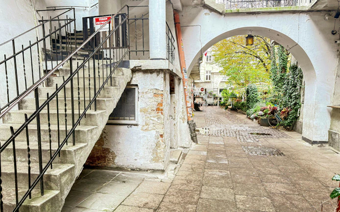 Courtyard in Krakow's Kazimierz district with historic staircase and archway.