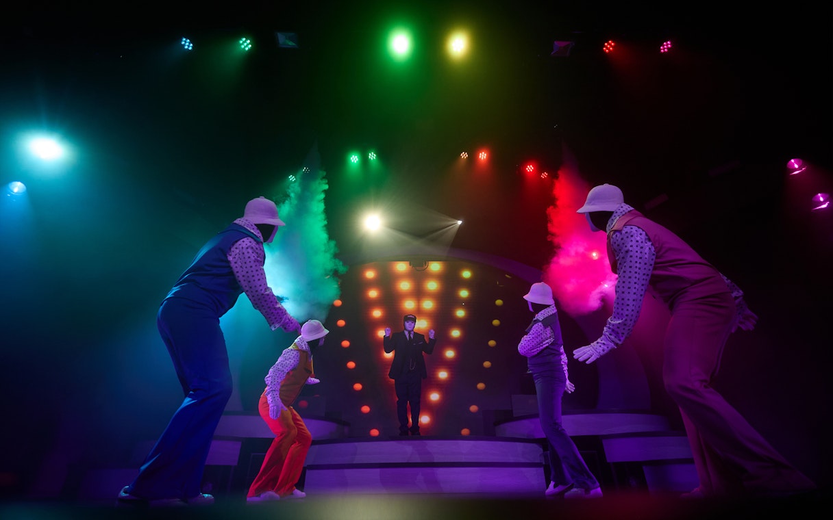 Jabbawockeez dancers performing on stage with colorful lights in Las Vegas show.