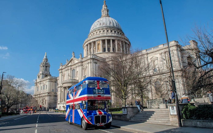 Double-decker bus with Union Jack near St. Paul's Cathedral, Central London.