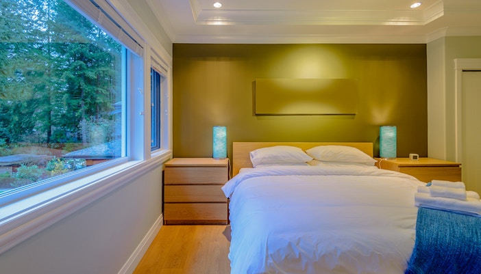 Luxury hotel room with large windows overlooking Fox Glacier, New Zealand.