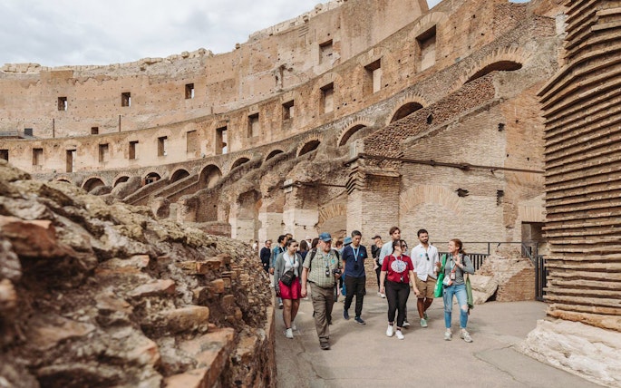 Tour group with guide exploring the Colosseum in Rome.
