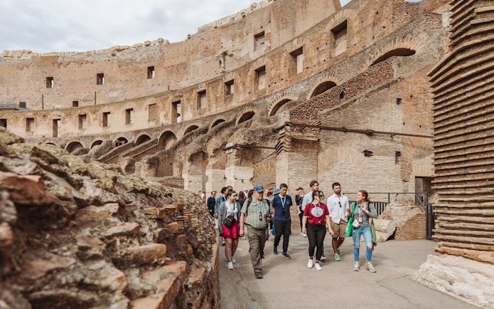 Tour group with guide exploring the Colosseum in Rome.