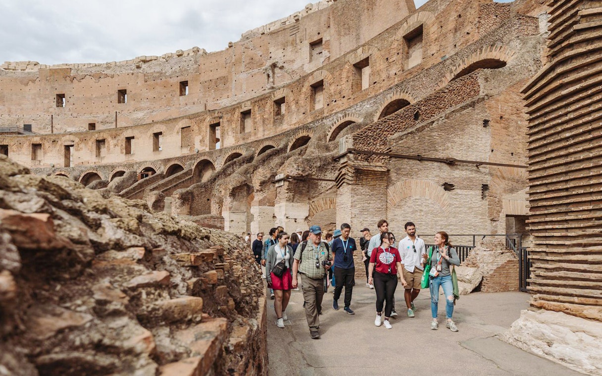 Tour group with guide exploring the Colosseum in Rome.