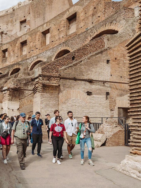 Tour group with guide exploring the Colosseum in Rome.