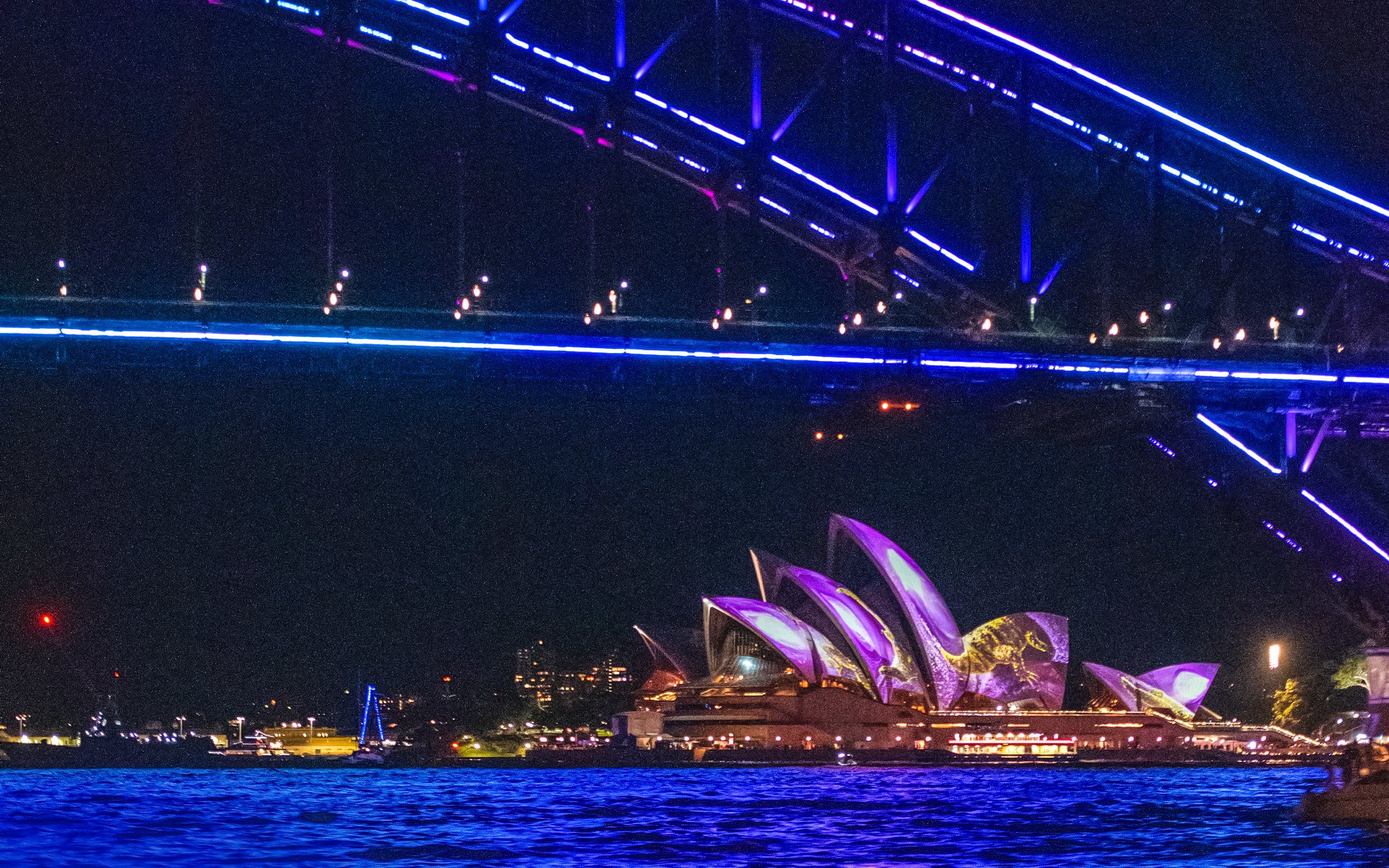 Sydney Opera House illuminated during Vivid Sydney cruise.