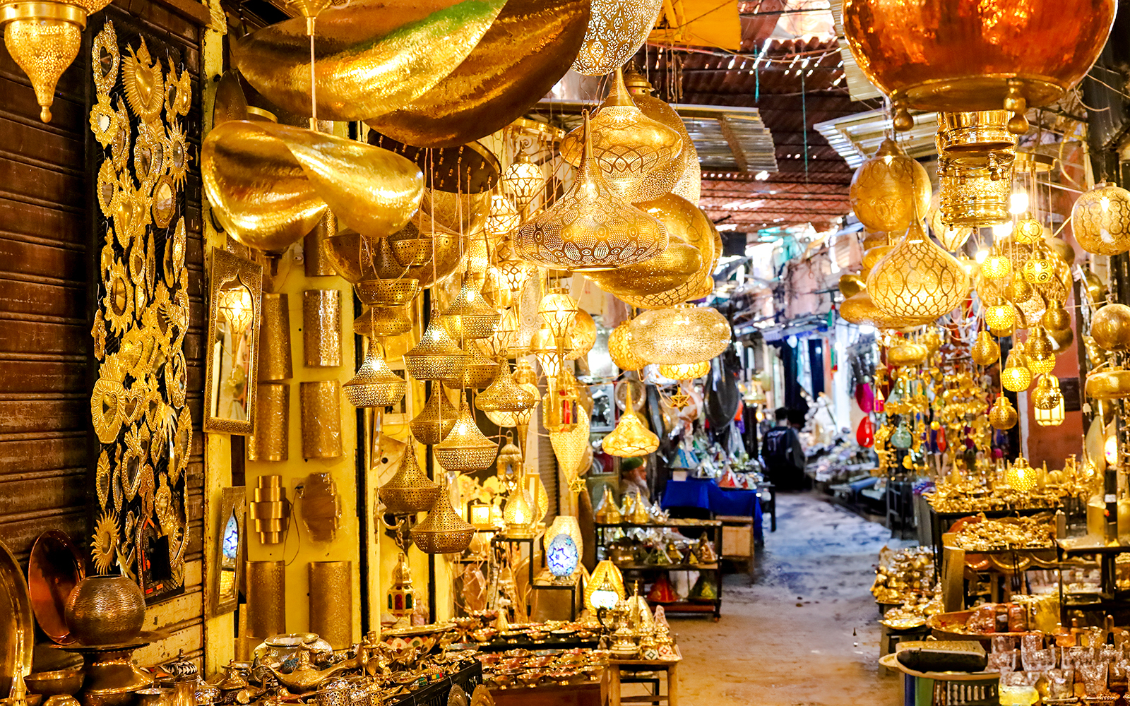 Marrakech souk with ornate golden lamps and vibrant market stalls.