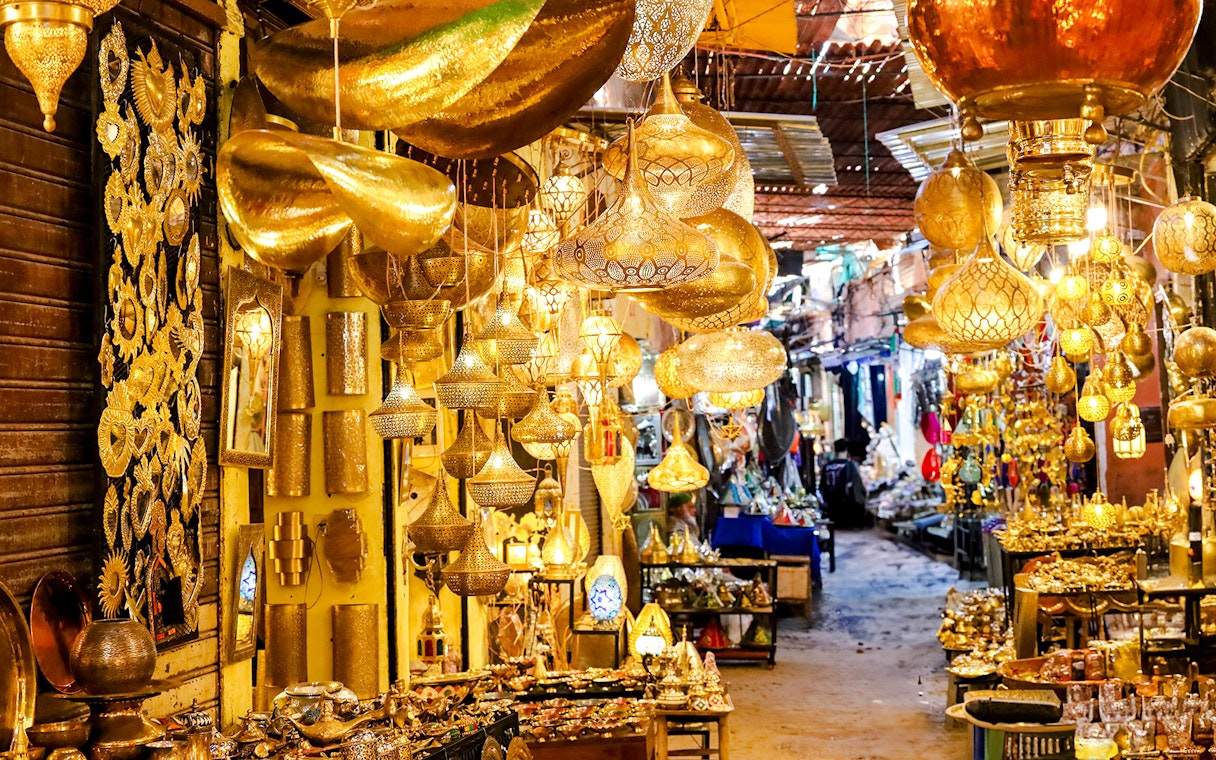 Marrakech souk with ornate golden lamps and vibrant market stalls.