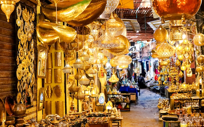 Marrakech souk with ornate golden lamps and vibrant market stalls.