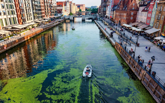 Electric boat cruising Gdansk harbour during Motława Sunset Cruise tour.