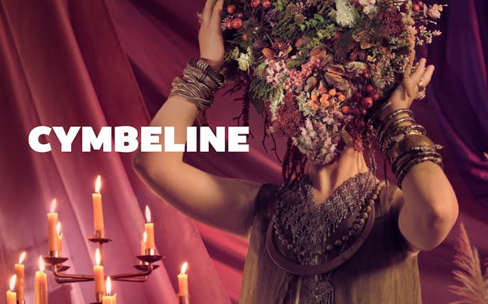 Person with floral headdress and candles, related to Cymbeline.