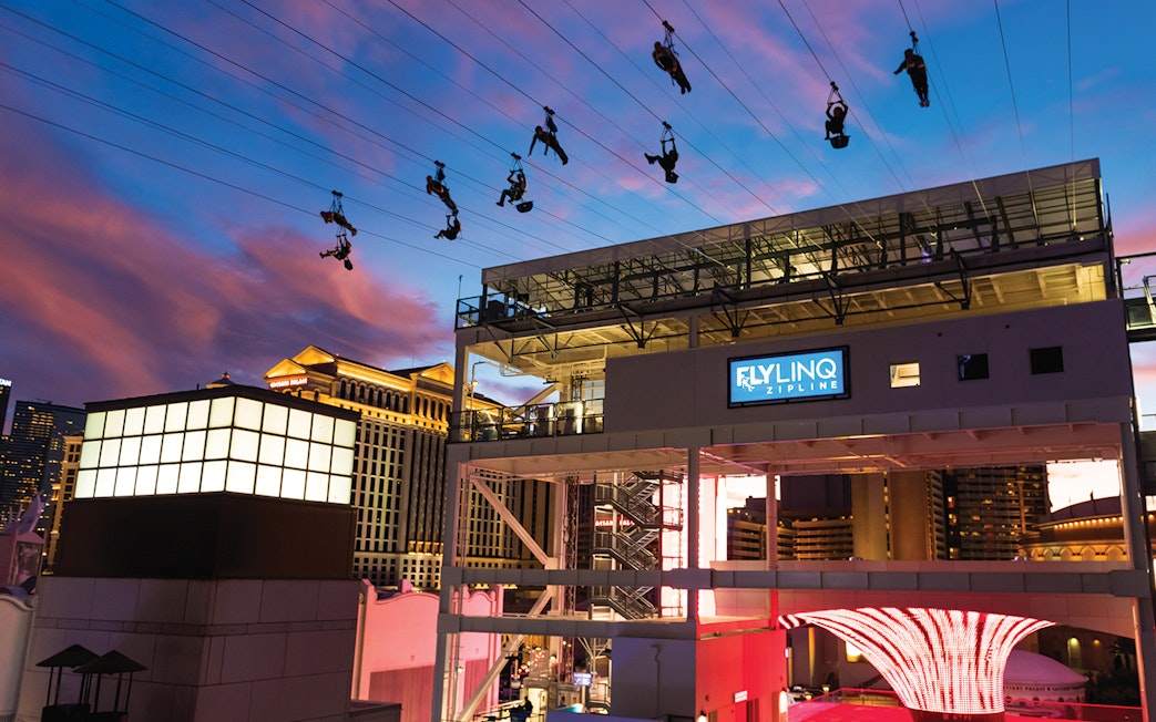 Fly LINQ Zipline riders above Las Vegas Strip at sunset.