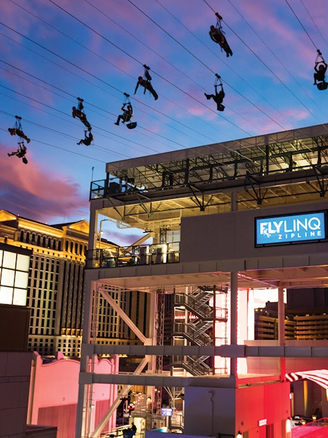 Fly LINQ Zipline riders above Las Vegas Strip at sunset.