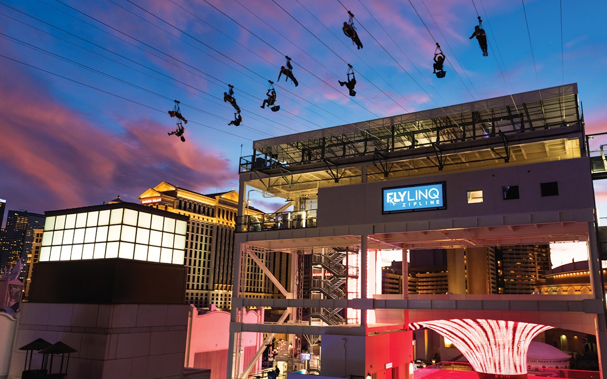 Fly LINQ Zipline riders above Las Vegas Strip at sunset.