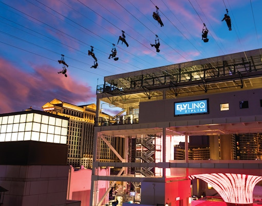 Fly LINQ Zipline riders above Las Vegas Strip at sunset.