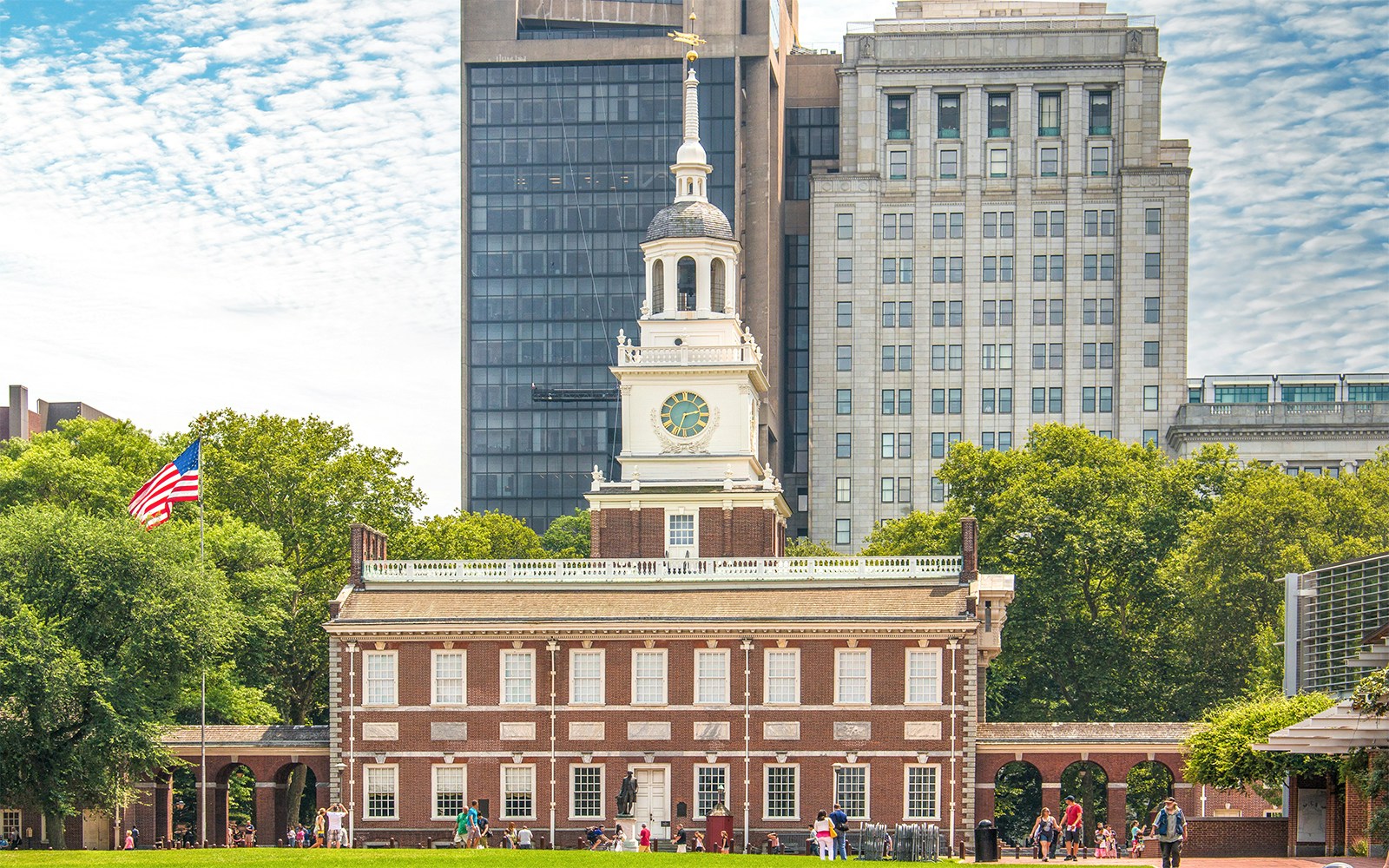 Hop-on hop-off bus at Independence Mall, Philadelphia, with tourists exploring historic landmarks.