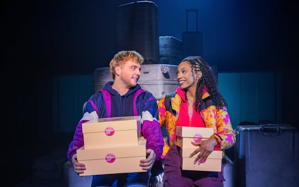 Two actors holding cake boxes on stage during "Two Strangers (Carry a Cake Across New York)" Broadway show.