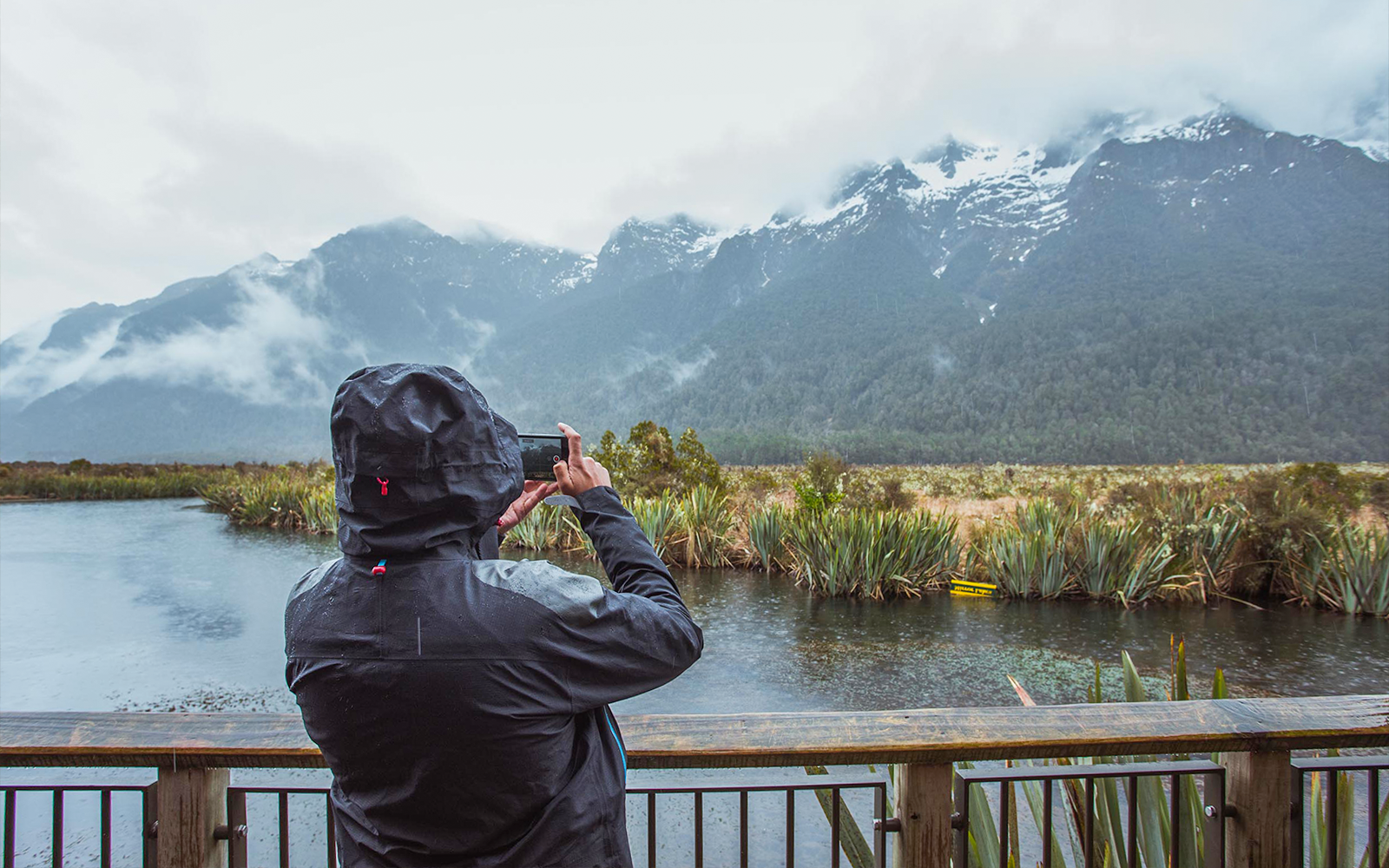 Tourist photographing the mountains surrounding Milford Lake