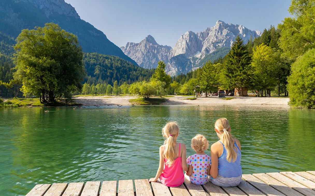 Guests sitting on a dock overlooking a lake in Triglav National Park, Slovenia.