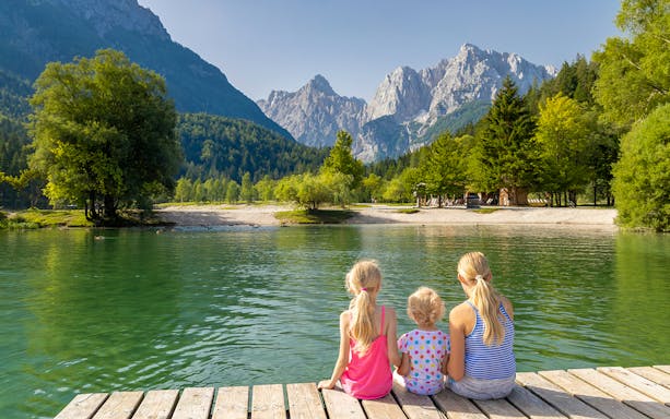 Guests sitting on a dock overlooking a lake in Triglav National Park, Slovenia.