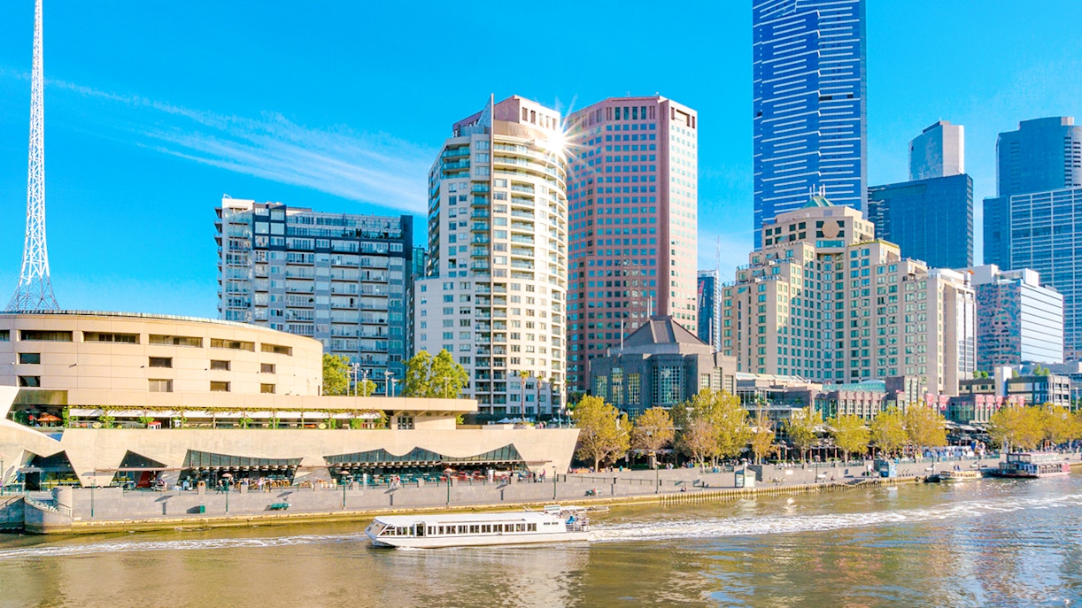 Cruise boat on Yarra River with Melbourne skyline in the background, Australia.