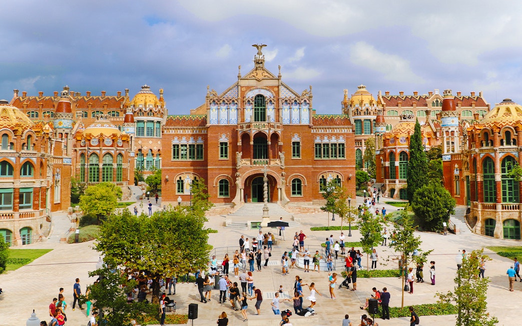 Sant Pau historical site in Barcelona with visitors exploring the courtyard.