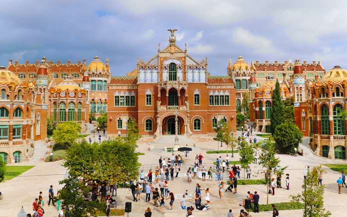 Sant Pau historical site in Barcelona with visitors exploring the courtyard.