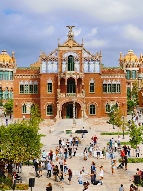 Sant Pau historical site in Barcelona with visitors exploring the courtyard.