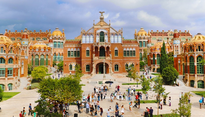 Sant Pau historical site in Barcelona with visitors exploring the courtyard.
