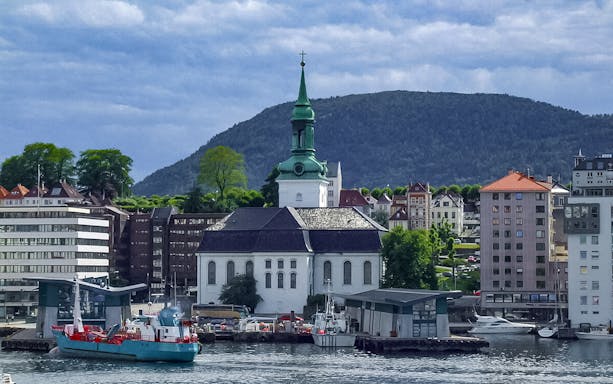 Bergen waterfront with historic church and buildings during sightseeing cruise.