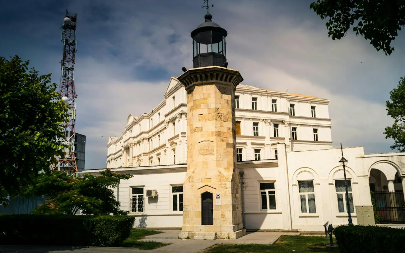 Historic lighthouse and building in Constanta, part of the self-guided city exploration game.