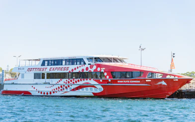 Rottnest Express ferry docked at a pier in clear blue water.