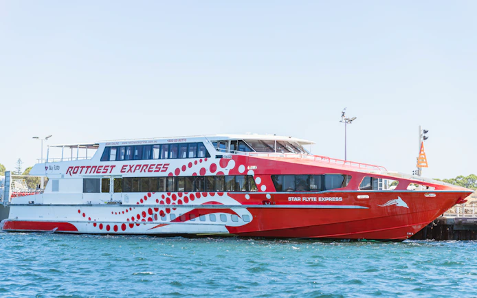 Rottnest Express ferry docked at a pier in clear blue water.