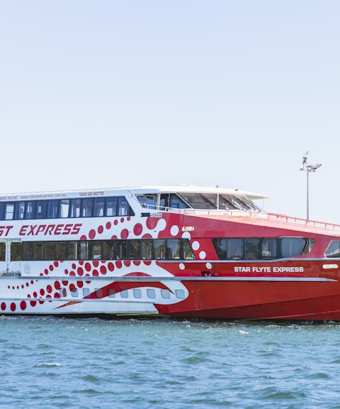 Rottnest Express ferry docked at a pier in clear blue water.