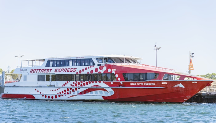 Rottnest Express ferry docked at a pier in clear blue water.