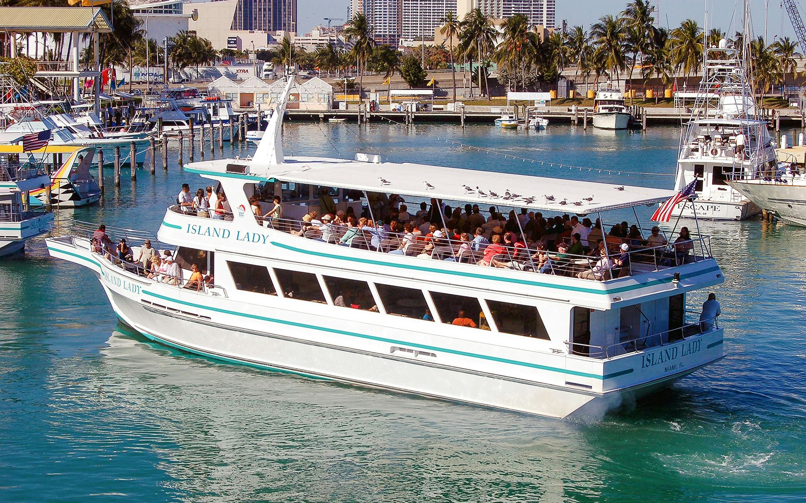 Tour boat docked at Bayside Marketplace, Miami, with city skyline in the background.