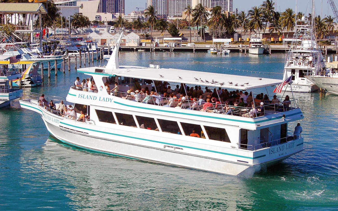 Tour boat docked at Bayside Marketplace, Miami, with city skyline in the background.