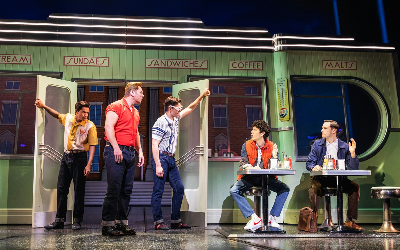 Actors performing a scene in a diner from Back to the Future the Musical.