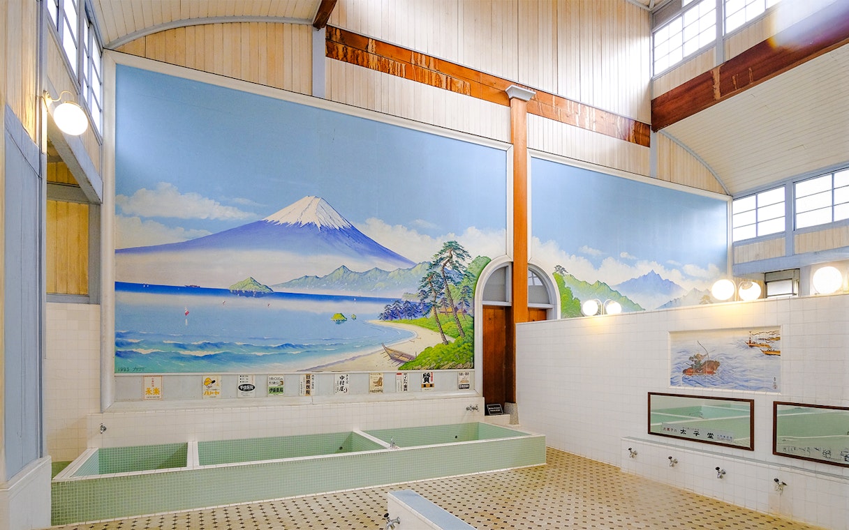 Public bath interior at Kotobuki-yu, Tokyo, featuring a mural of Mount Fuji.