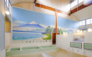 Public bath interior at Kotobuki-yu, Tokyo, featuring a mural of Mount Fuji.