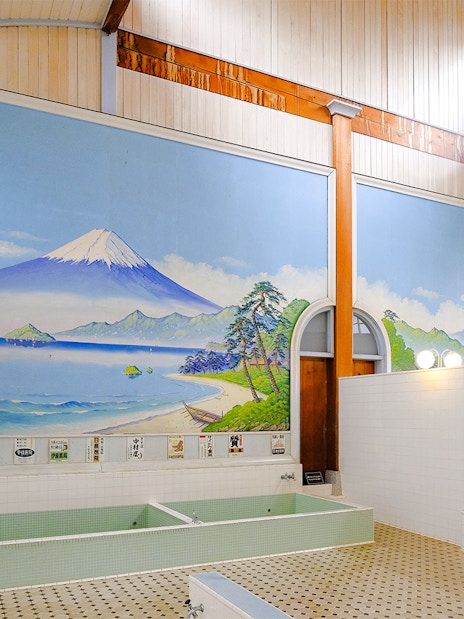 Public bath interior at Kotobuki-yu, Tokyo, featuring a mural of Mount Fuji.