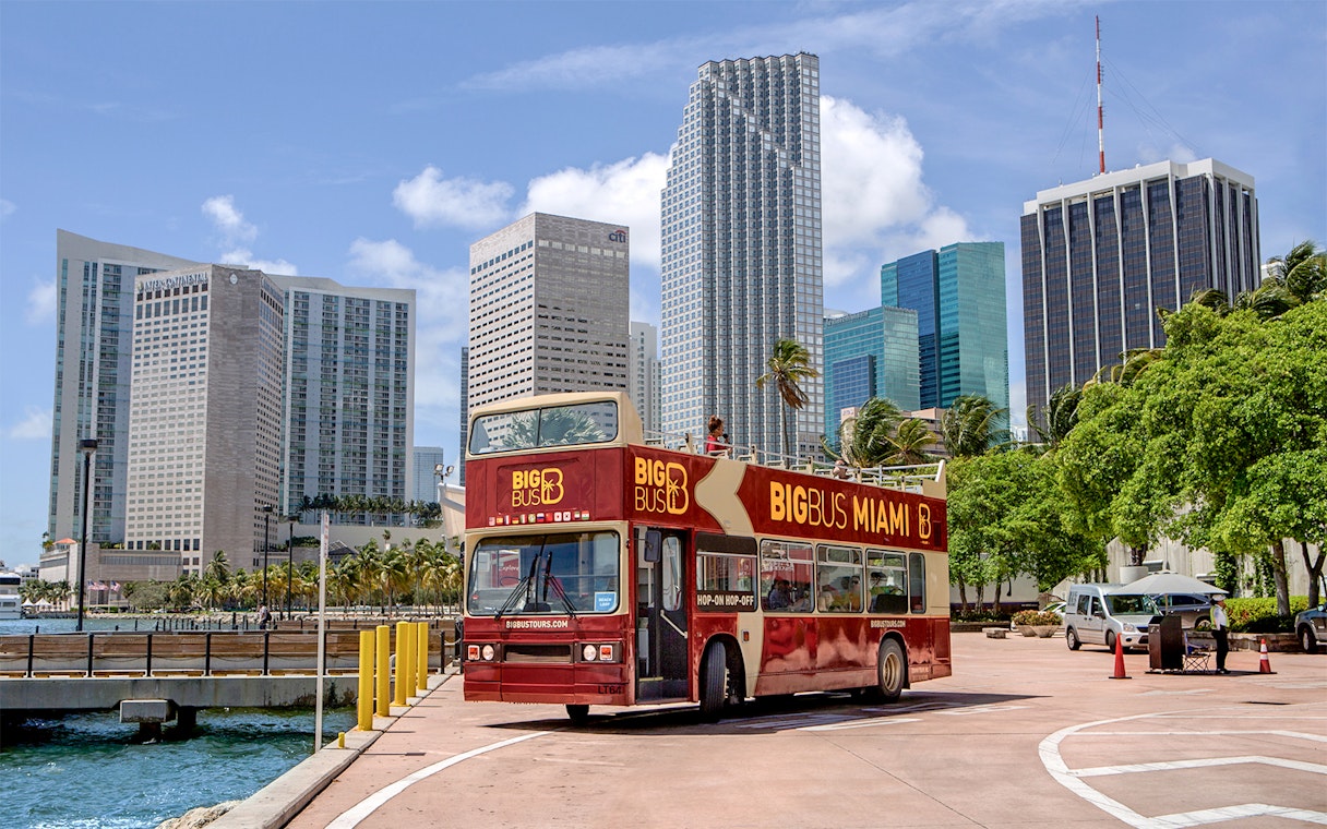 Miami double-decker bus tour with city skyline in the background.
