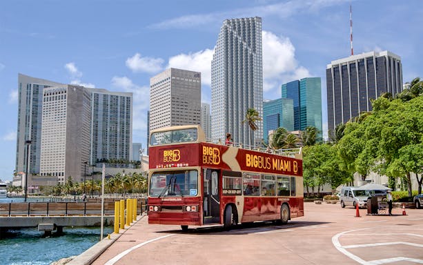Miami double-decker bus tour with city skyline in the background.