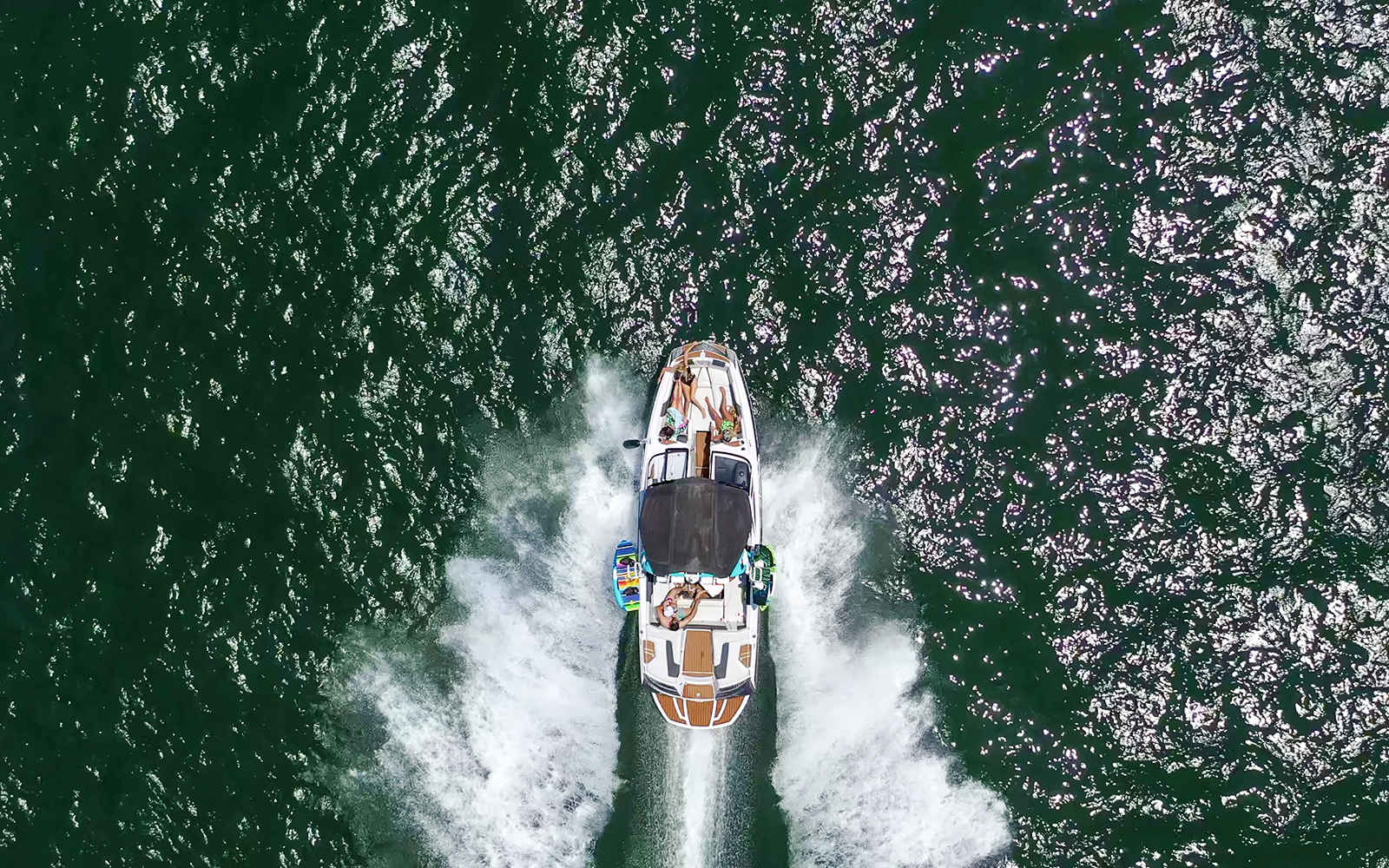 Speed boat with people cruising on open water.