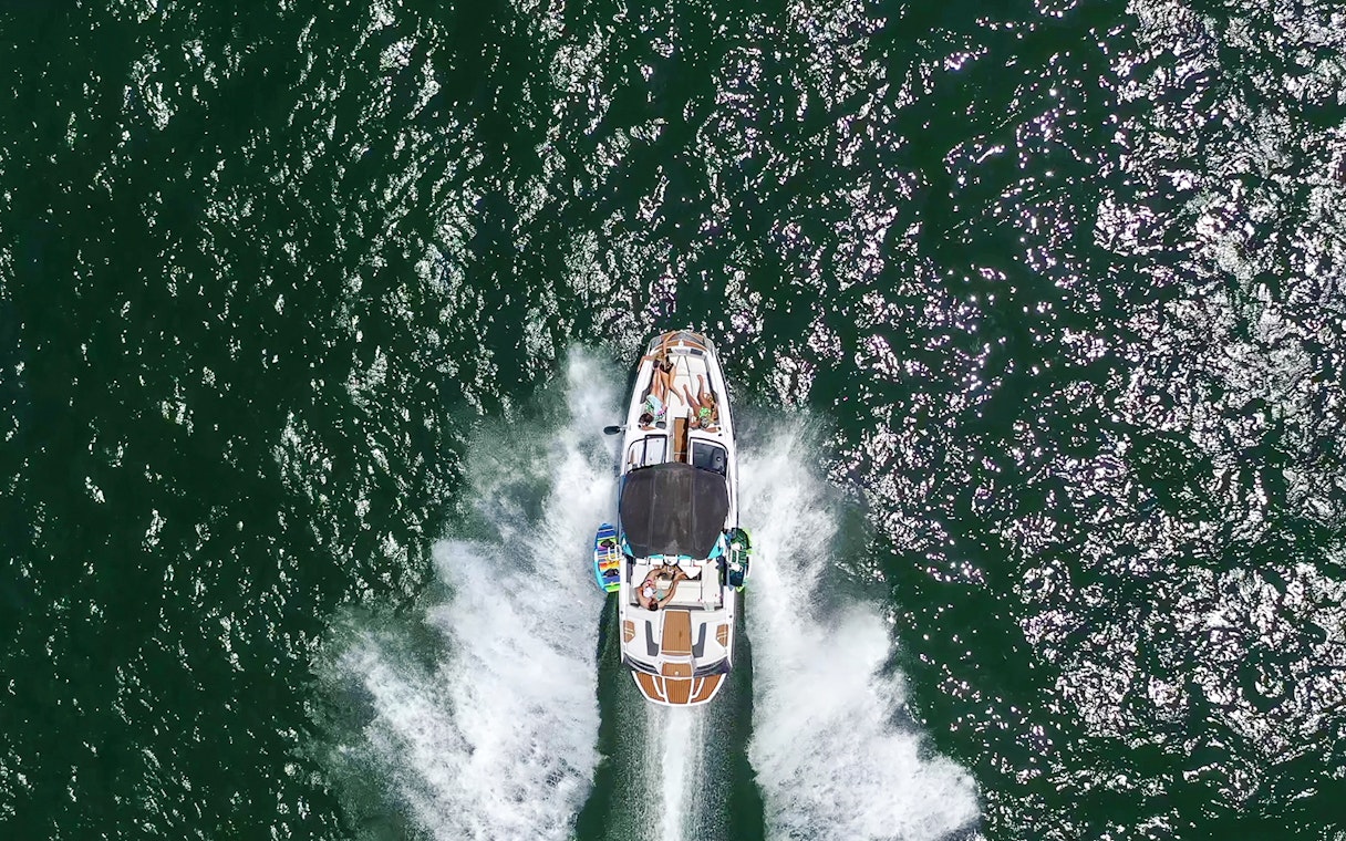 Speed boat with people cruising on open water.