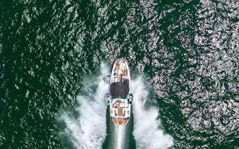 Speed boat with people cruising on open water.