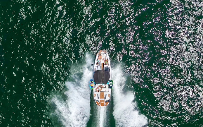 Speed boat with people cruising on open water.